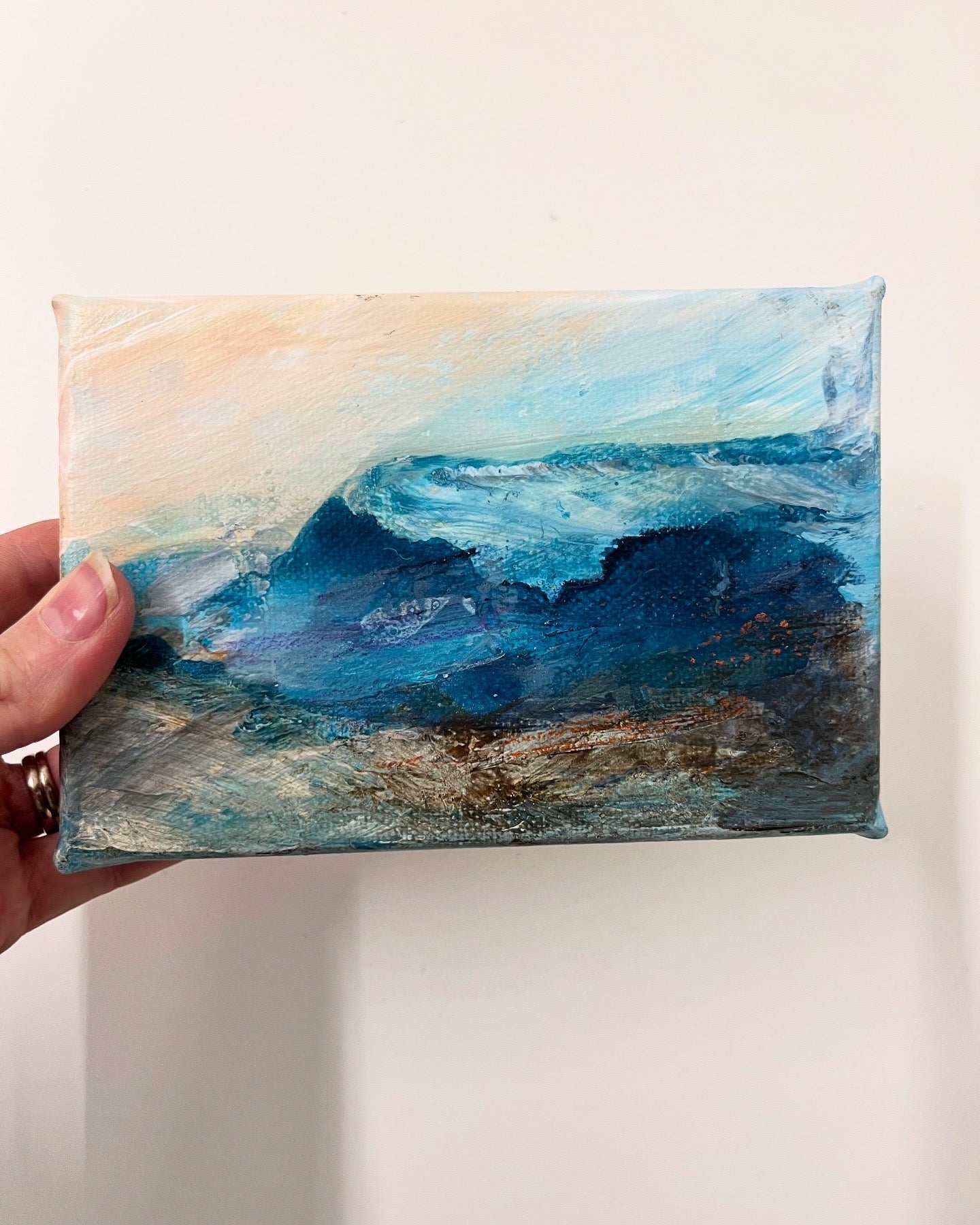 Fragments of Calm IV small landscape painting by British contemporary Landscape artist Nicola Briggs photo shows box canvas held in hand for size