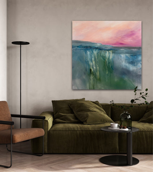 Modern living room with a green sofa, brown armchair, and abstract landscape painting on the wall with a pink sunrise sky and mist over the water
