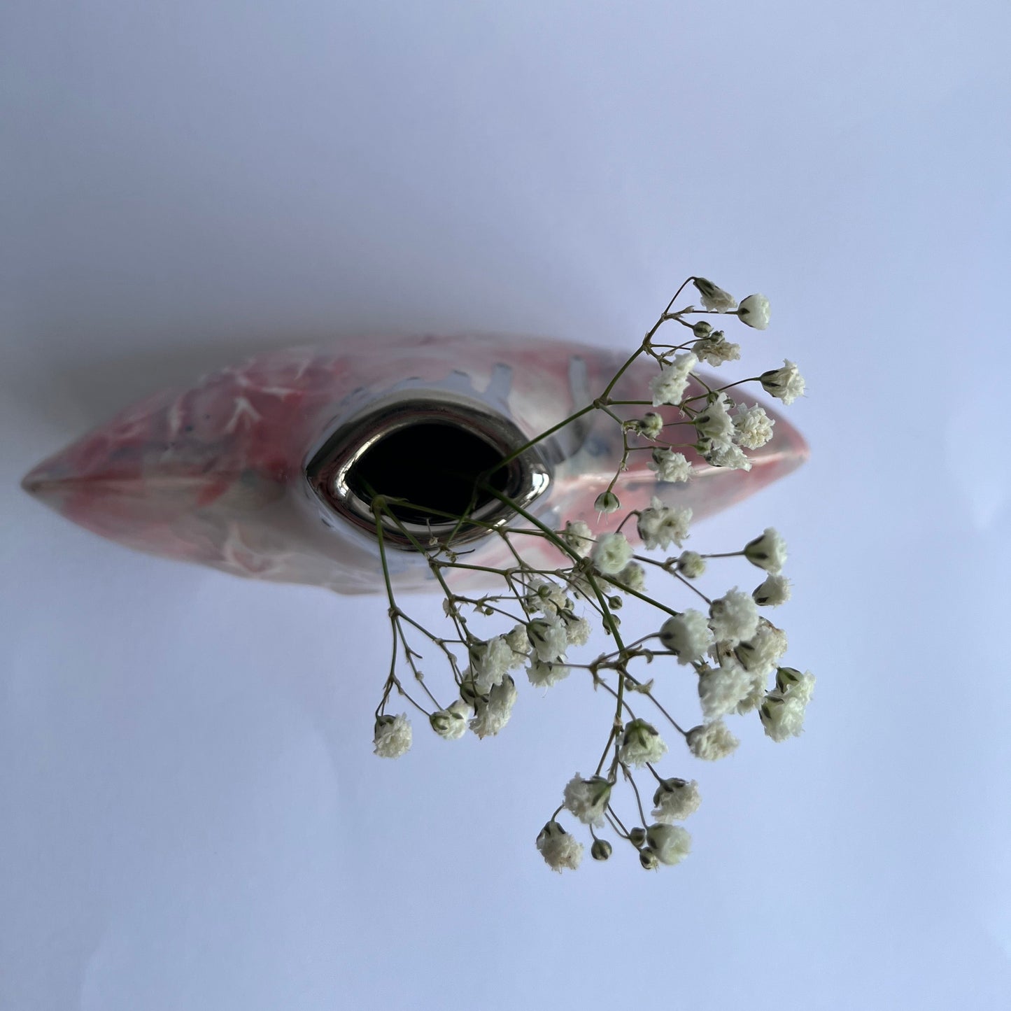 Pink silhouette bottle vase from above with flowers inside handbuilt by Nicola Briggs