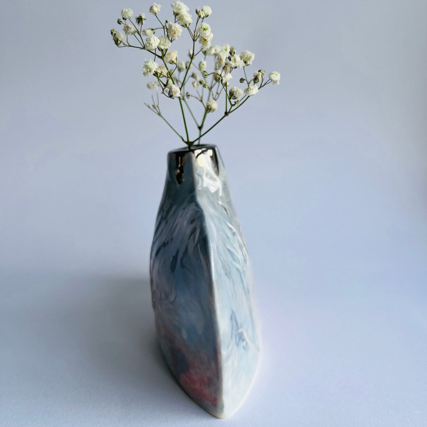 side profile pic of grey and pink Silhouette Bottle vase handbuilt in porcelain with gypsophila inside