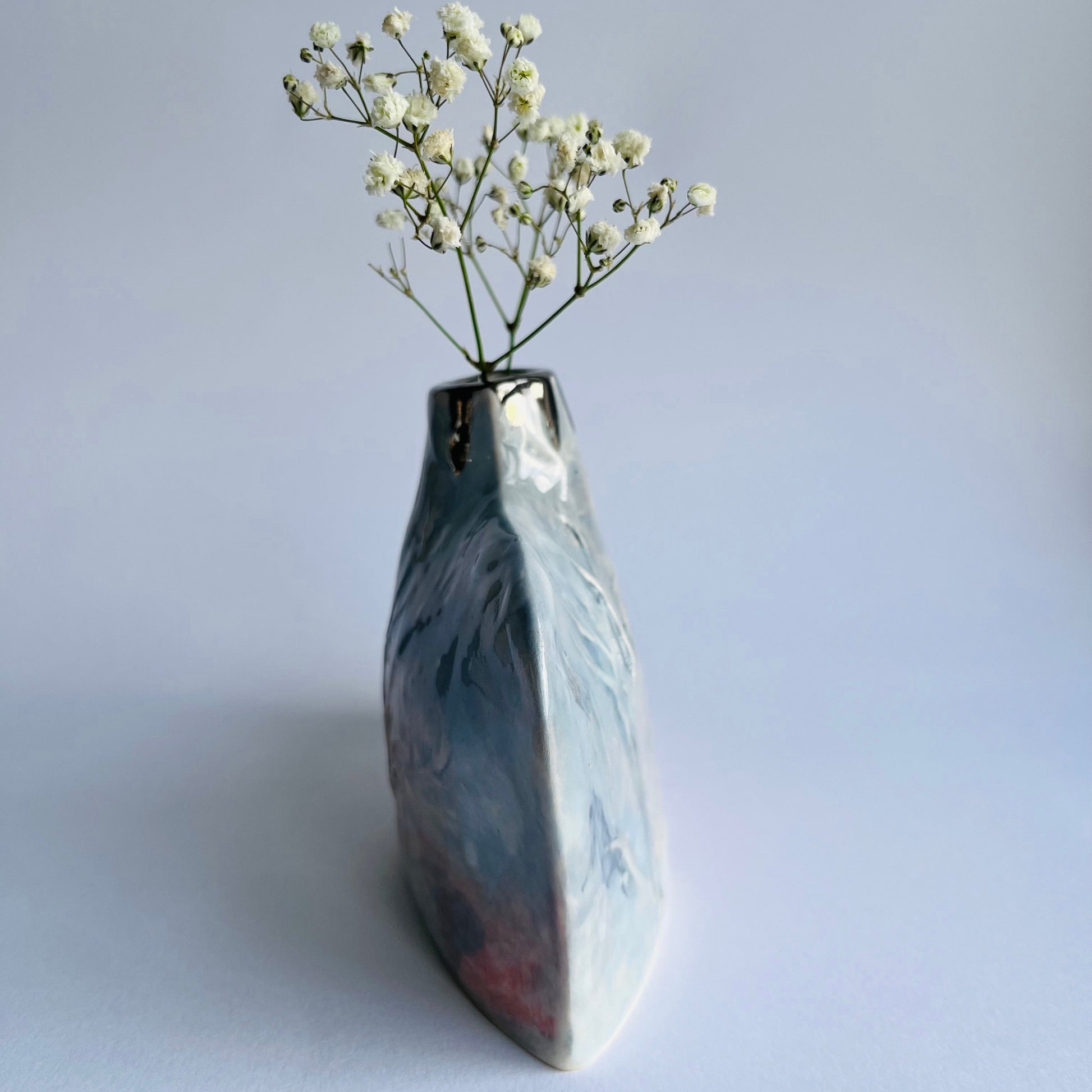 side profile pic of grey and pink Silhouette Bottle vase handbuilt in porcelain with gypsophila inside