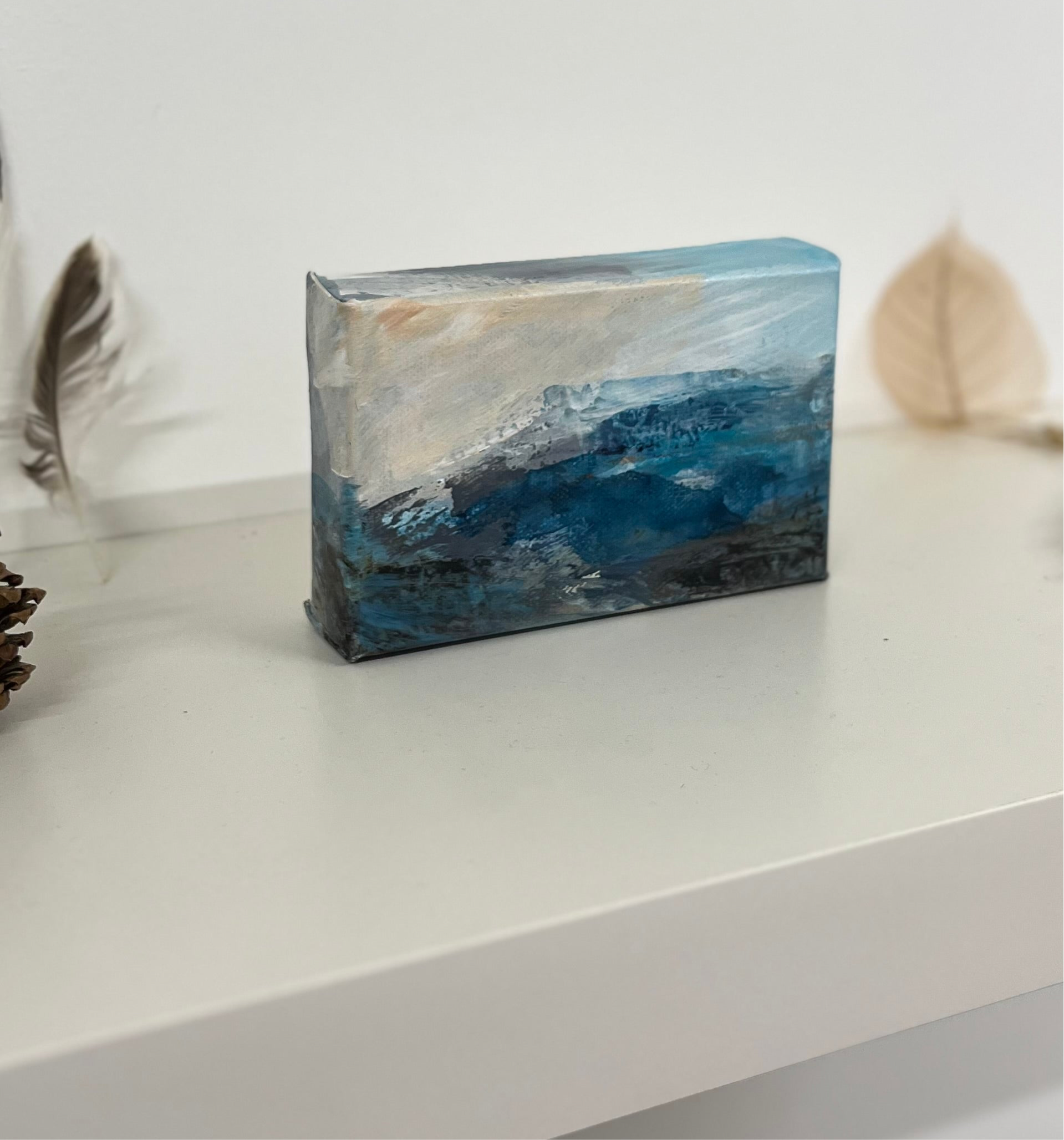 Fragments of Calm III small landscape painting by British contemporary Landscape artist Nicola Briggs photo shows box canvas on studio shelf  for size