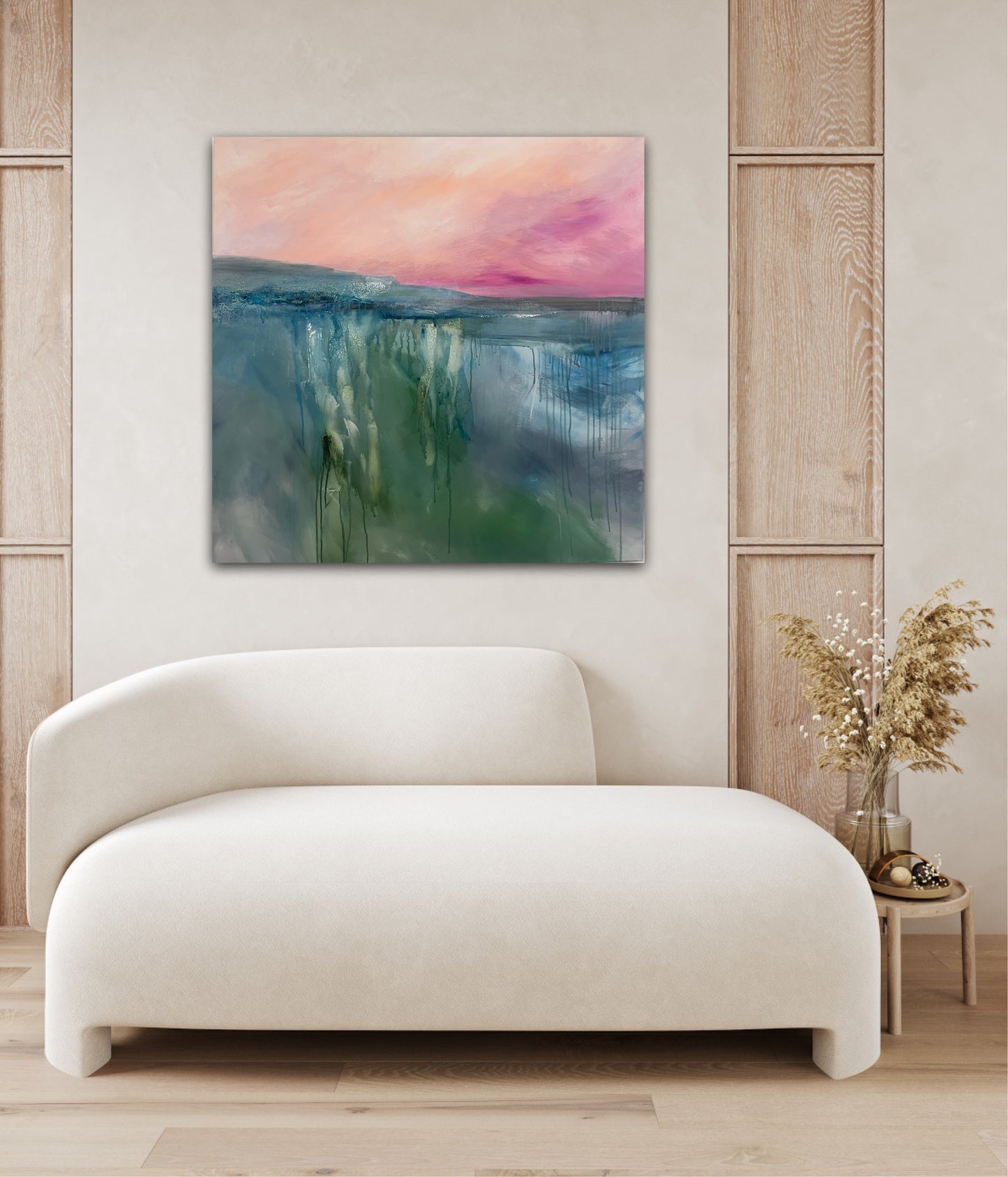 Abstract landscape painting on a wall above a white sofa in a room with wooden paneling.