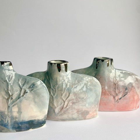 Silhouette flat bottles handbuilt in porcelain with relief winter tree design greys, pinks and blue by ceramicist Nicola Briggs 