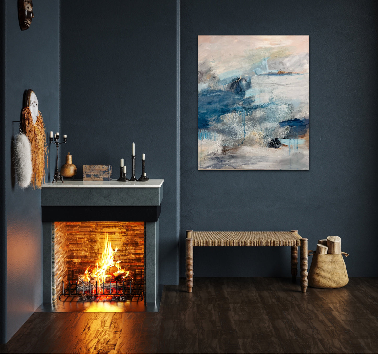 The atmospheric painting hangs on a dark blu wall above a rattan bench near to an open fire burning brightly 