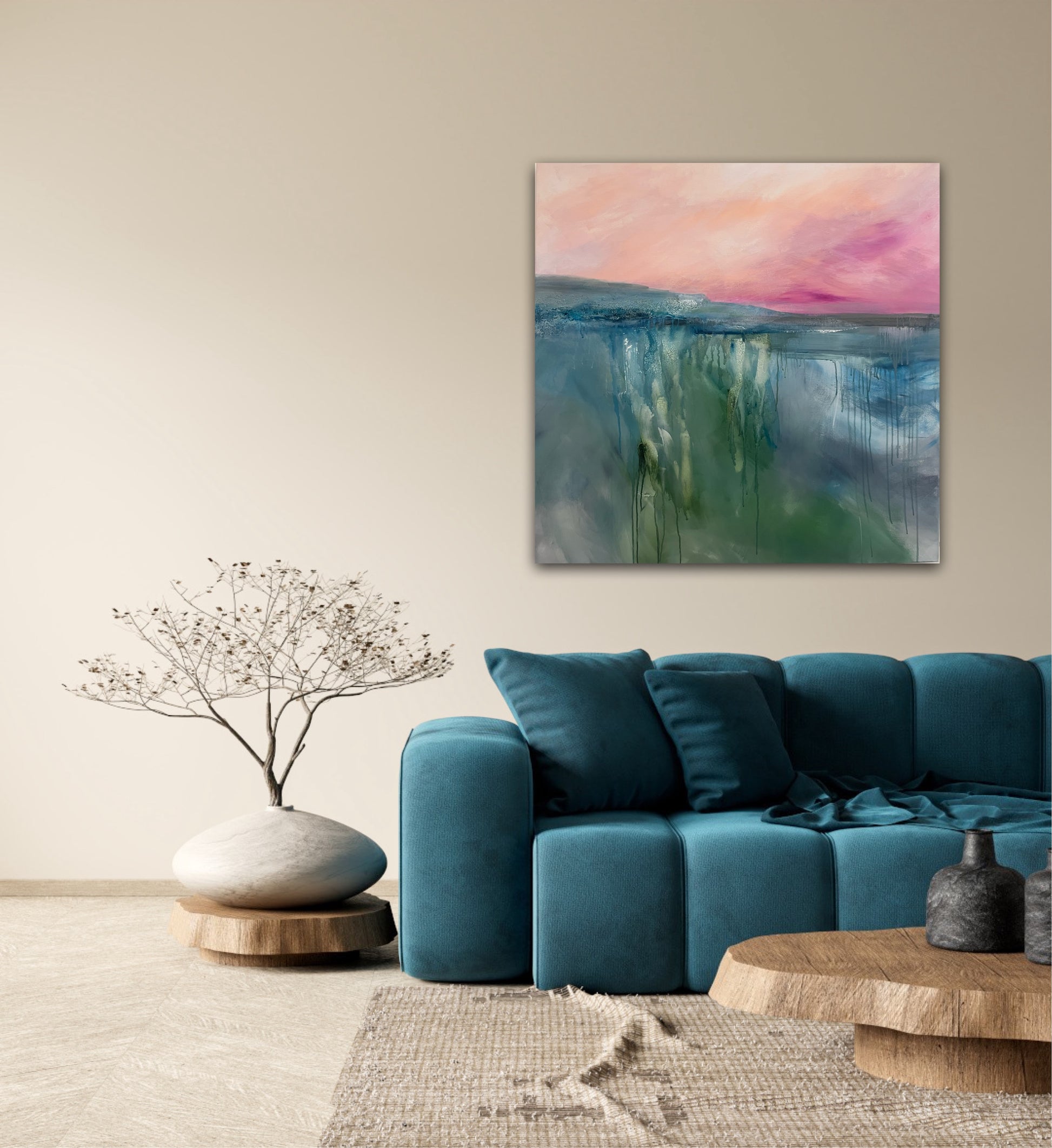 Living room with a blue sofa, decorative plant, and abstract painting of a sunrise landscape on the wall by Nicola briggs 